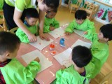 老师在教小朋友们怎样涂颜料